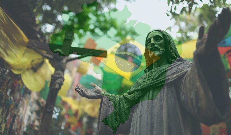Statue of Jesus with outstretched arms overlaid with the map and flag of Brazil, surrounded by colorful decorations