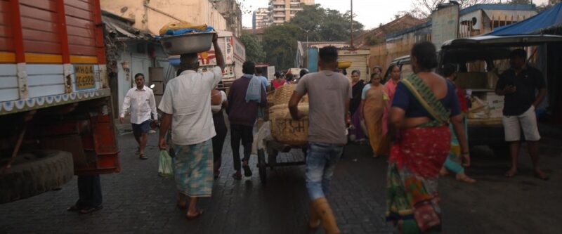 Crowded street market with people in traditional Indian clothing